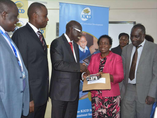 Education PS Belio Kipsang handing over the digital content to Jomo Kenyatta University of Agriculture Technology (JKUAT) Vice Chancellor Mabel Imbuga at the Kenya Institute of Curriculum Development yesterday.Photo Courtesy