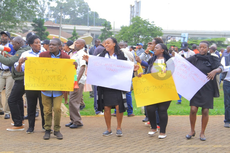 Public sector union members carry placards while demonstrating against government's 3 per cent housing levy on University Way in Nairobi on May 29, 2023.