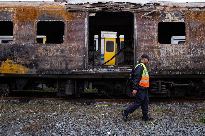 A Metrorail official walks passed a charred train carriage in Cape Town it is one of several carriages damaged in arson attacks