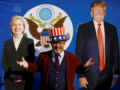 A man poses for a picture near the cardboard cutouts of U.S. presidential nominees Hillary Clinton (L) and Donald Trump, at an election event hosted at the U.S. ambassador's residence in Kathmandu, Nepal November 9, 2016. REUTERS/Navesh Chitrakar