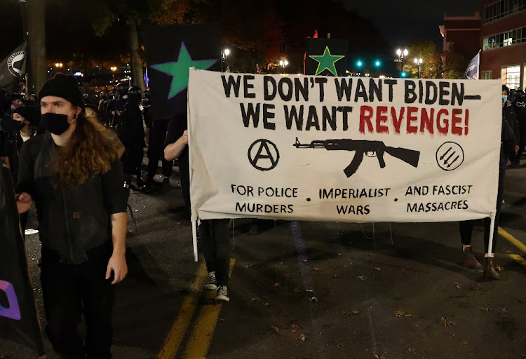 Demonstrators carry a banner during a protest the day after Election Day, in Portland, Oregon, U.S., November 4, 2020.