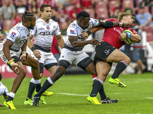 Rohan Jansen van Rensburg of the Lions is tackled by Lwazi Mvovo of the Sharks at Emirates Airline Park yesterday.