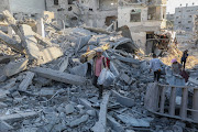 People inspect damage and remove items from their homes after Israeli airstrikes on April 7 2024 in Khan Yunis, Gaza. File photo.