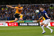 Wolverhampton Wanderers' Raul Jimenez shoots at goal under pressure from Everton's Michael Keane during a Premier League match at Molineux Stadium, Wolverhampton, on August 11, 2018.