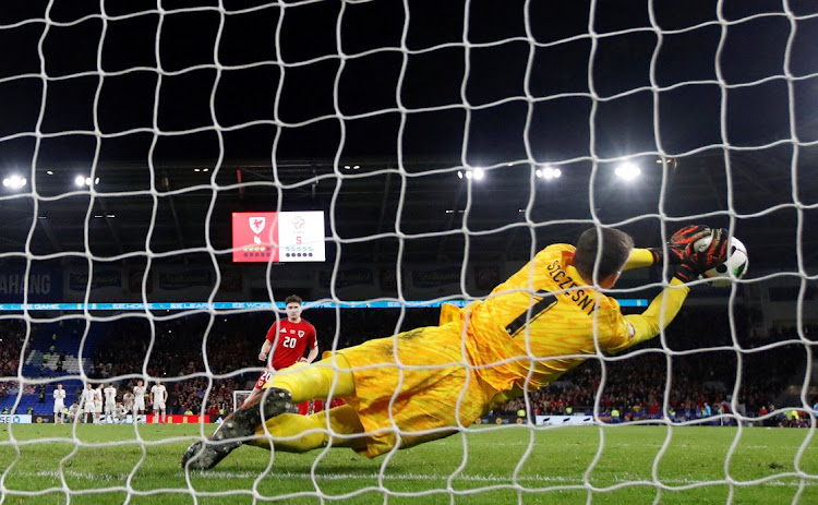 Poland's Wojciech Szczesny saves Wales' Daniel James penalty to win the penalty shootout and help his country qualify for Euro 2024 in their playoff qualifier at Cardiff City Stadium on March 26, 2024