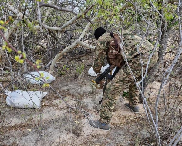A police officer examines items found at an al Shabaab base in Garissa after a raid on Sunday, March 24, 2024.