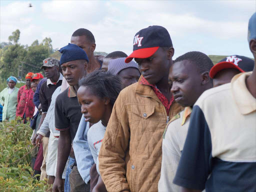 Residents along the Nairobi Maai Mahiu highway at Kinenie forest in Lari watch two bodies of the young men.