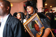 Vela Nyembe, slain deputy principal Hubert Nyembe's aunt, holds his picture as they carry him to his final resting place  on Saturday in KwaThema, Ekurhuleni. Photos:  KABELO MOKOENA