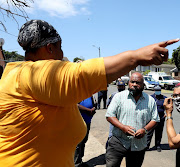 An angry resident raises her concerns with ward councillor Aubrey Snyman (right) in the presence of police on Tuesday. 