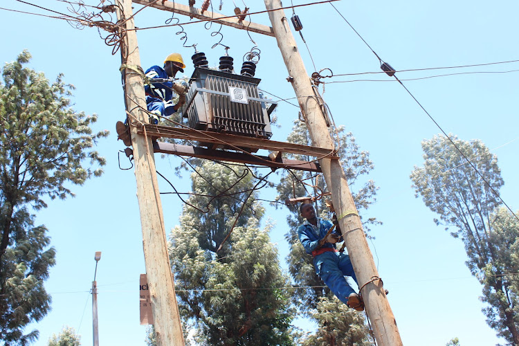Kenya Power workers install a brand new transformer at Kiawaihiga shopping centre after vandalism of the former one on April 6, 2022.