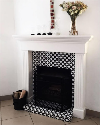 The Circled Flower ceramic tile makes an ideal decorative touch in this fireplace.