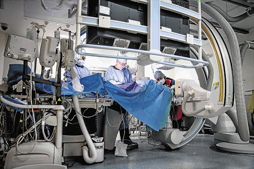 KING OF HEARTS: Dr Joe McKibbin inserting a biodegradable scaffold into a woman's heart at a hospital in Johannesburg yesterday. Unlike the metal stents usually used in heart surgery, the scaffolds dissolve