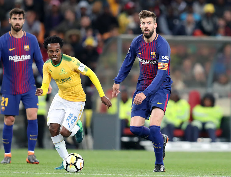 Mamelodi Sundowns' star forward Percy Tau dribbles away from Barcelona's Gerald Pique during the Nelson Mandela Centenary Cup friendly match at FNB Stadium, Johannesburg on May 16 2018.