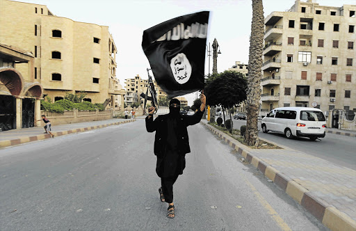 A militant of the Islamic State waves the group's flag in Raqqa, Syria. The group has targeted Egypt.