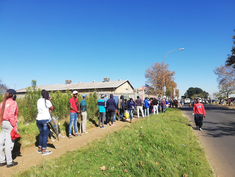 Soweto recipients in a long queue at the Pimville post office wait to collect their R350 grants.