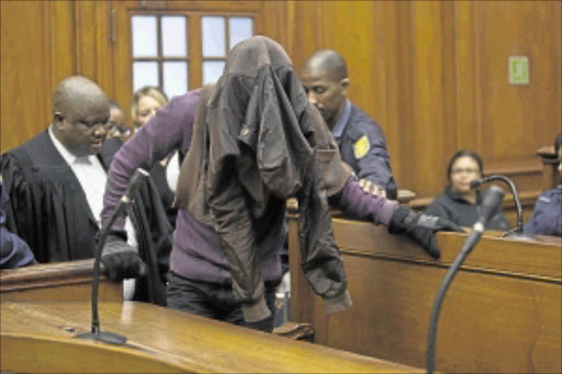 HIDING: Xolile Mngeni at his trial in the Cape Town High Court. He is accused of Anni Dewani's murder. Photo: Gallo Images