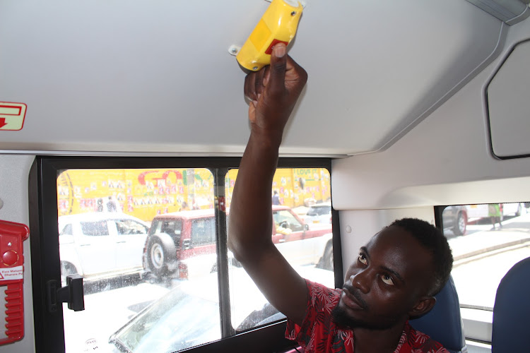 A passenger presses a button to stop the bus during a trip from CDB to JKIA, on April 4, 2022