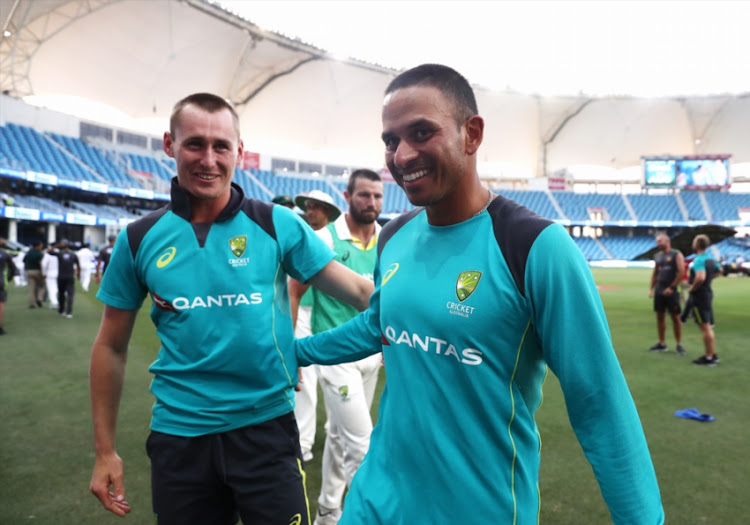 Usman Khawaja and Marnus Labuschagne of Australia celebrate after Australia held on to draw the test match during day five of the First Test match in the series between Australia and Pakistan at Dubai International Stadium on October 11, 2018 in Dubai, United Arab Emirates.