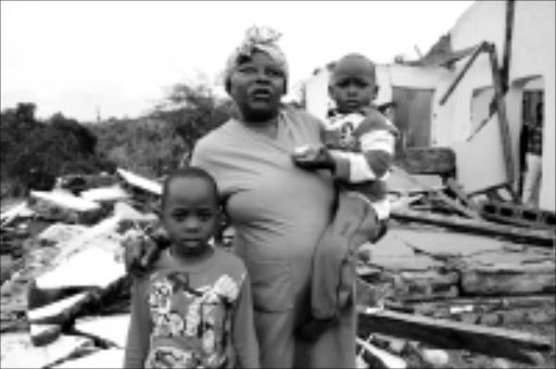 AFTERMATH: More than 400 people were left homeless at KwaMakhutha in Durban on Saturday. Beauty Makhaya with her grandchildren Wandile and Linda. 29/11/2008. Pic. Thuli Dlamini. © Sowetan.