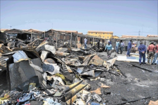 MASS DESTRUCTION: Langa informal settlement residents in Zone 24 rebuilding their shacks after a fire ravaged them on Sunday evening. About 80 shacks burnt to ashes and 300 people were left homeless. PHOTO: UNATHI OBOSE