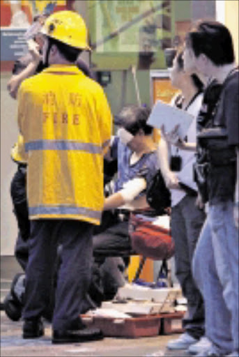 A man receives medical treatment after being injured by acid in a street in Hong Kong's shopping district Mongkok Saturday, May 16, 2009. Two bottles of acid were thrown into a crowd of people on Saturday, injuring 30 people, according to police and news reports. (AP Photo/Kin Cheung)