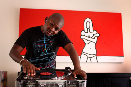 DJ Euphonik at the decks trying out a pair of earphones