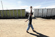 The ANC in the Western Cape complain of how people in informal settlements still the bucket system as a resident of Joe Slovo walks pass a line of toilets on her way to her house after filling up at one of the outside taps.