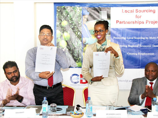Nakumatt Supermarket’s regional operations and strategy director iagarajan Ramamurthy and Comesa CBC CEO Sandra Uwera exchanging documents after signing a Memorandum of Understanding to enable Nakumatt source goods from certifi ed suppliers in the region. /COURTESY