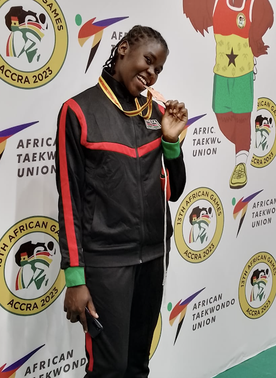 Jully Musangi displays her brionze medal after winning