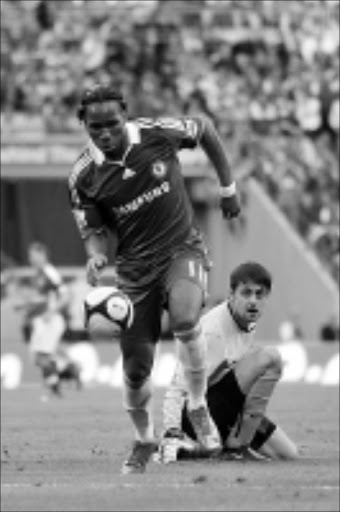 MADE EASY: Chelsea's Didier Drogba, left, passes Arsenal's goalkeeper Lukasz Fablanski to score during their English FA Cup semifinal soccer match at Wembley Stadium on Saturday. 18/04/09. Pic. Matt Dunham. © AP.