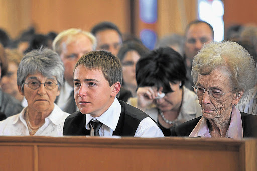 SURVIVOR: A tearful Don Steenkamp at the funeral of his parents and sister on Thursday. He is flanked by his grandmothers, Martie Massyn, left and Bettie Steenkamp Pictures: SIMON MATHEBULA