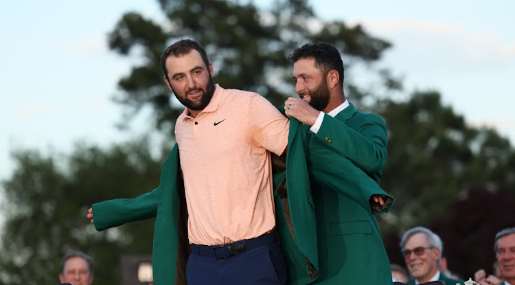 Scottie Scheffler of the US is presented with the green jacket by Spain's Jon Rahm after winning The Masters at Augusta National Golf Club in Augusta, Georgia on Sunday. Picture: Reuters/Eloisa Lopez