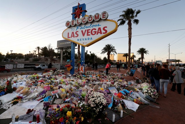 The "Welcome to Las Vegas" sign is surrounded by flowers and items, left after the October 1 mass shooting, in Las Vegas, Nevada, US October 9, 2017.