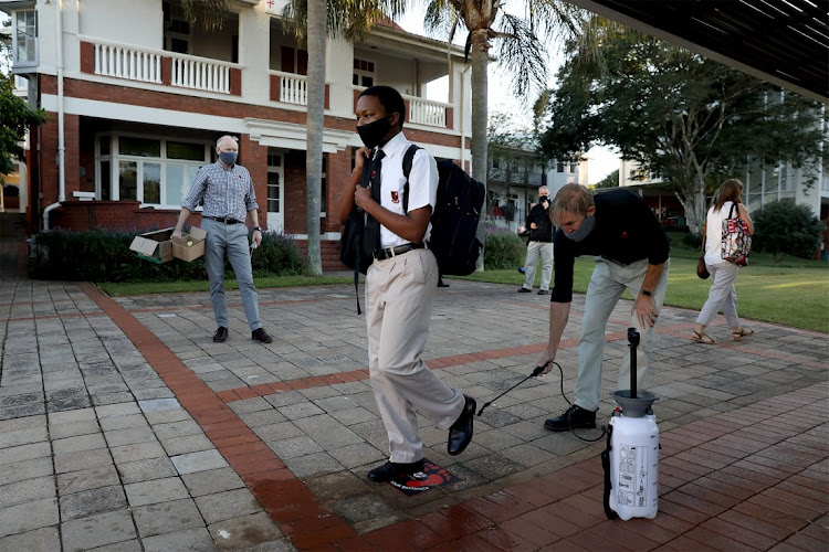 Azola Lukhozi,12, a grade 7 pupil at Clifton College in Durban is getting disinfected as he enters the schools premises.