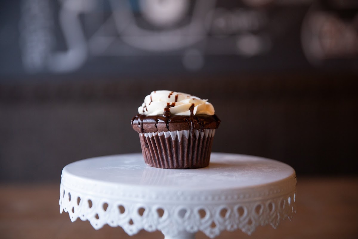 Flourless molten chocolate cupcake - chocolate cake filled with duche de leche ganache and topped with french buttercream frosting and chocolate drizzle.