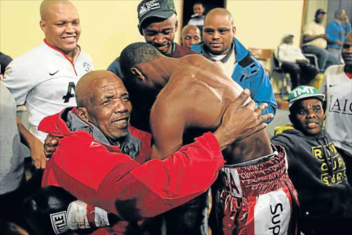 RING LUMINARY: Ailing promoter Mzi Mnguni is embraced by a boxer during a tournament in 2014. A tournament involving Simpiwe Konkco will be held at the Orient Theatre on November 20 to pay tribute to the recuperating Mnguni Picture: FILE