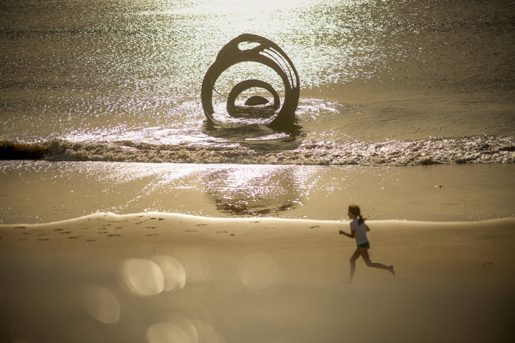 A child runs on the beach, past Mary's Shell, an art installation, at Thornton-Cleveleys on September 05, 2023 in Blackpool, United Kingdom. The UK is experiencing a late summer heatwave as temperatures are expected to reach 31 degrees celsius later this week.