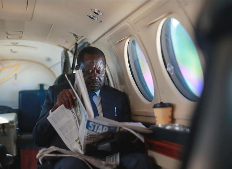 ODM leader Raila Odinga reads the Star newspaper aboard a private jet on his way to Juba in 2019.