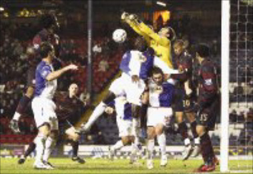 HEMMED IN: Arsenal's goalkeeper Lukasz Fabianski punches the ball away from goal during their English League Cup quarterfinal against Blackburn Rovers at Ewood Park Stadium in Blackburn, England, on Tuesday. Pic. Paul Thomas. 18/12/07. © AP.