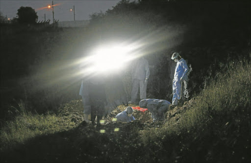 BROUGHT TO LIGHT: Members of SAPS at Orlando field in NU2 Mdantsane, where the remains of a body were discovered yesterday Picture: MARK ANDREWS