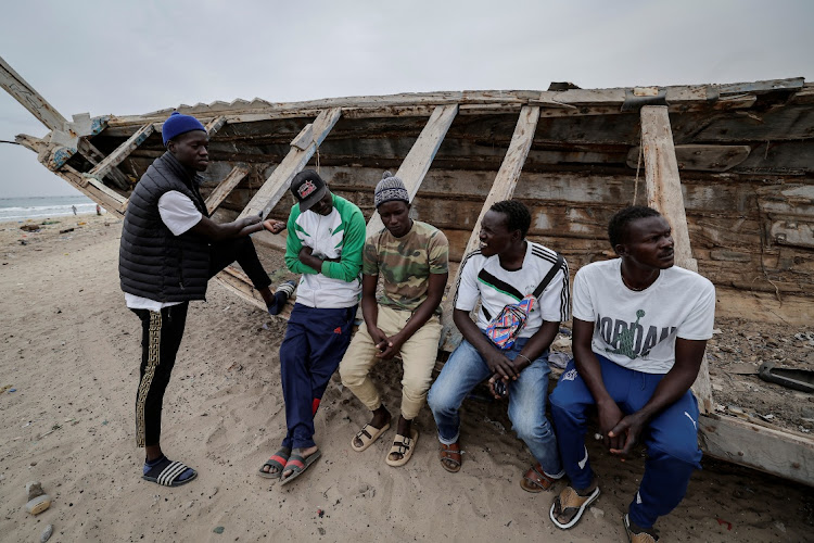 Fisherman Birane Mbaye (right), one of the survivors of a disastrous attempt to reach Spain last year on a boat that drifted hundreds of miles off course and ended up off the Cape Verde archipelago, sits on a pirogue with other survivors on the beach in Fass Boye, Senegal, in this February 1 2024 file photo. Picture: ZOHRA BENSEREMA/REUTERS