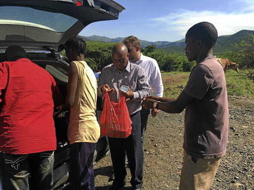 FILE IMAGE: Herman Mashaba speaks to former employees of Lily Mine and family members of the three trapped miners in Louisville, outside Barberton.