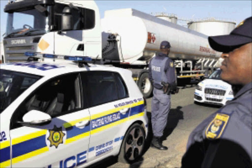 Heavily armed police from the Gauteng Flying Squad prepare to escort a petrol tanker leaving the Alberton depot, south of Johannesburg. Talks to end the petrol industry strike are due to resume today.