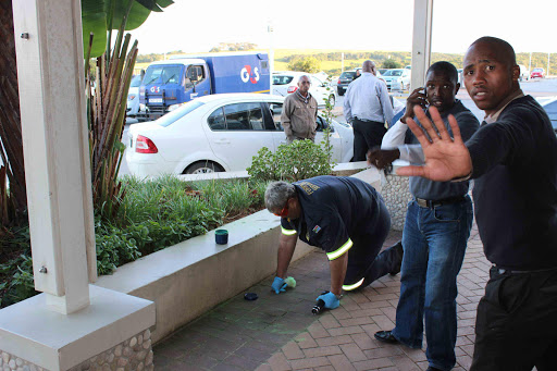 SEARCHING FOR CLUES: A police forensics expert looks for evidence at the shopping mall yesterday afternoon Picture: DAVID MACGREGOR