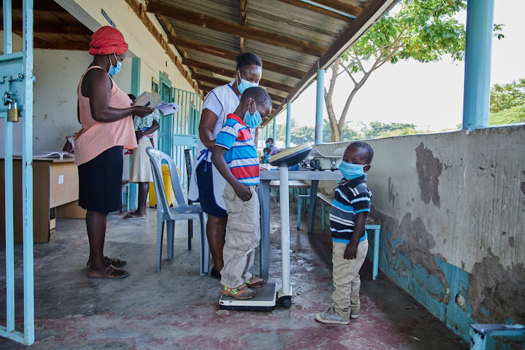 David and Dahzur are weighed and measured by a nurse at Bunde Health Centre.