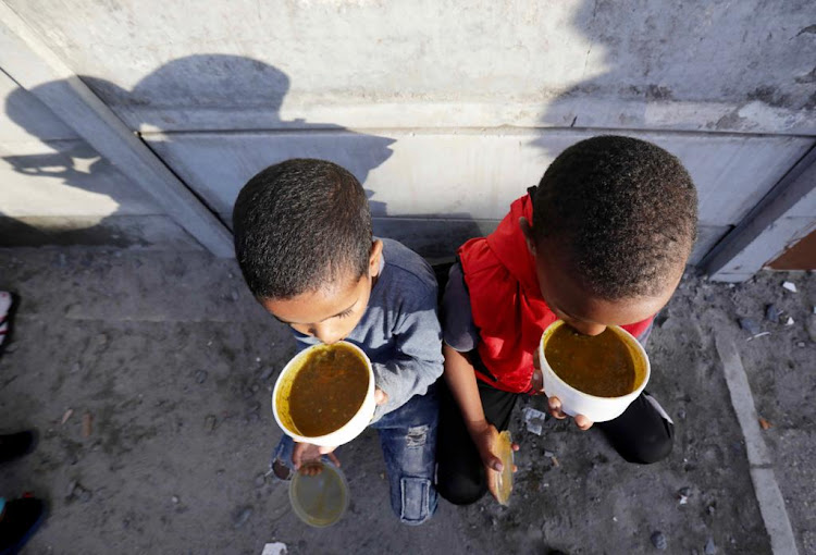 Naeem Eli and Shadley Nomdoe, both eight years old, enjoy a cup of soup provided by Moms Who Care in Hanover Park.