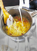 Adding cream to the spicy mixture