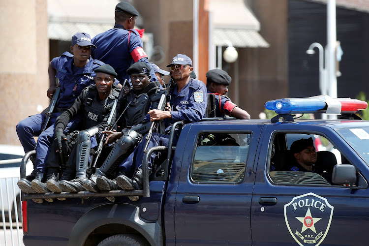 Congolese policemen drive past Congo's Independent National Electoral Commission (CENI) headquarters in Kinshasa, Democratic Republic of Congo, on January 9 2019.