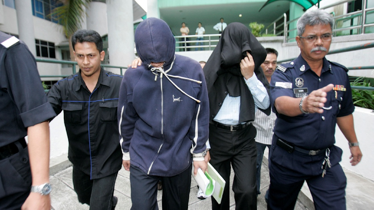 Policemen Azilah Hadri (2nd L) and Sirul Azhar Umar (2nd R) arrive at the courthouse in Shah Alam outside Kuala Lumpur January 15, 2009.