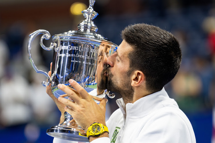 Novak Djokovic of Serbia kisses a trophy that he won in a past championship.